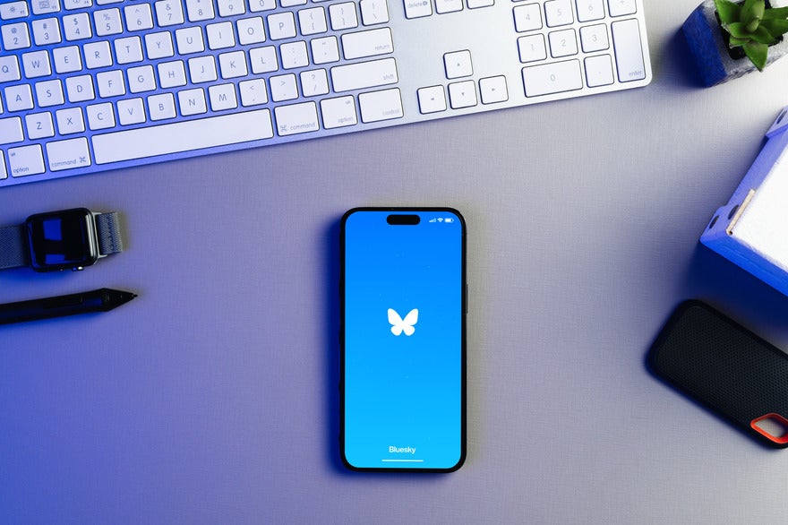 Mobile on a desk showing the Bluesky logo