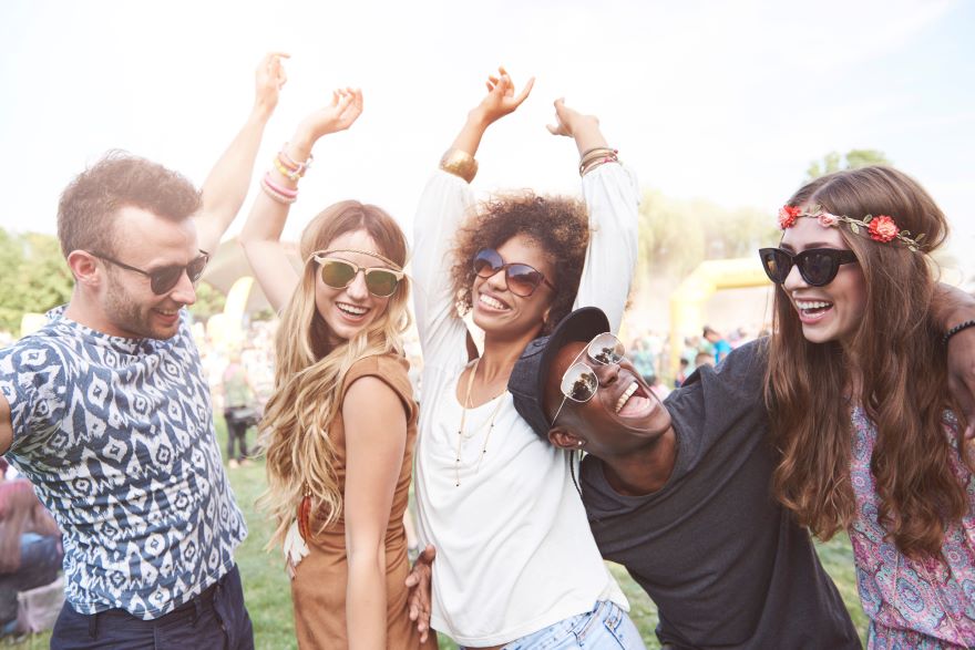 A group of 5 friends dancing together at a festival