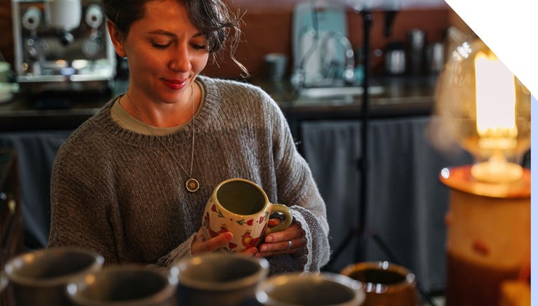 Woman admires custom mug in shop
