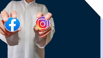 Person in white shirt holding up a sticker of the Facebook logo and the Instagram logo in each hand