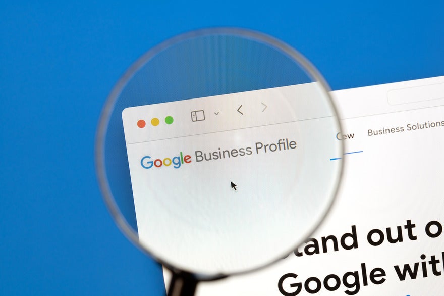 Magnifying glass hovering over a browser showing the Google Business Profile homepage
