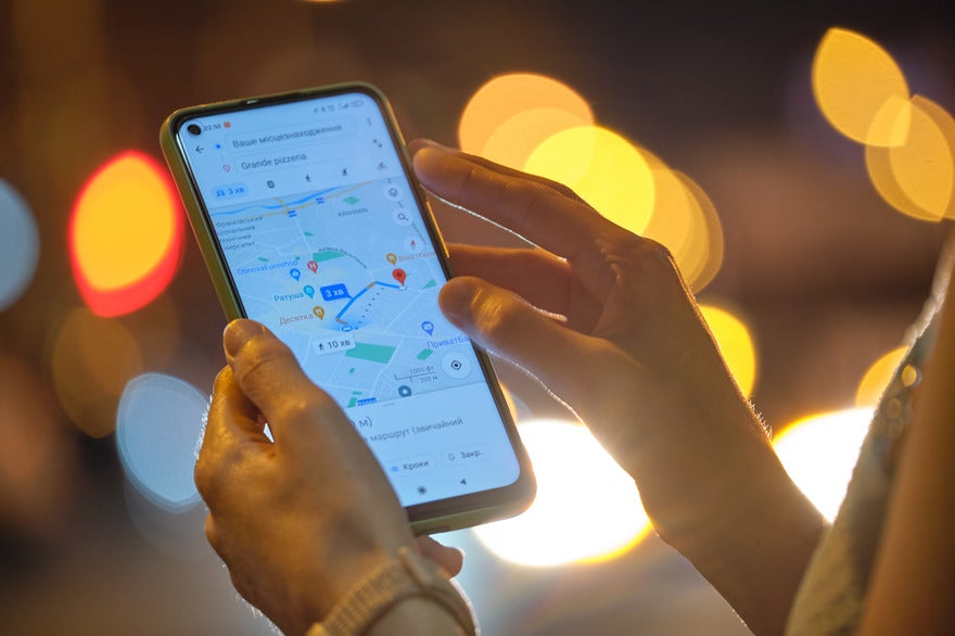 Person holding a mobile device showing Google Maps on the screen