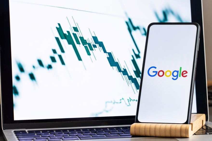 A smartphone on a stand with the Google logo on screen