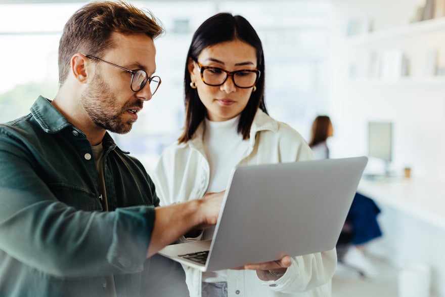 A man and woman starting at a laptop together