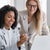 Two women smiling and pointing at a laptop screen