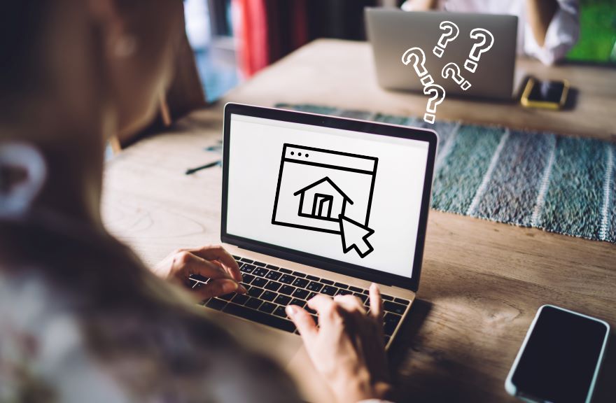 A person types on a laptop, displaying a home icon on the screen, surrounded by question marks, suggesting confusion or inquiry.