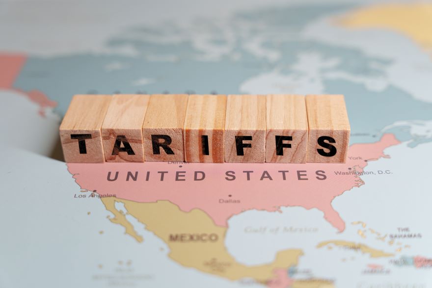 A closeup of the US on a map with letter blocks spelling "tariffs" on top
