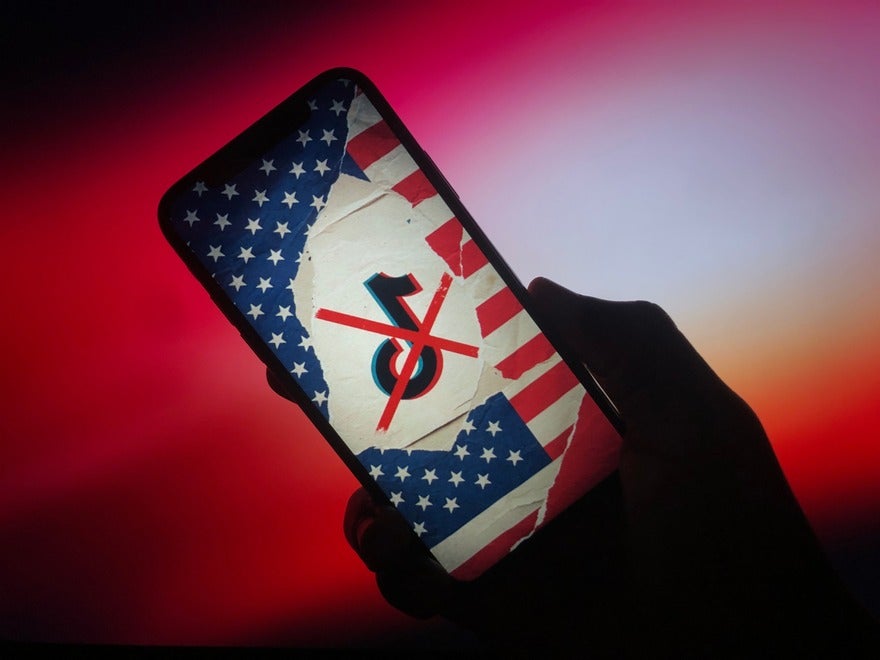 Phone screen showing a collage with the TikTok logo placed on top of the American flag and there's a red cross through the logo
