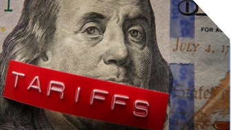 US money with a printed label on top saying tariffs