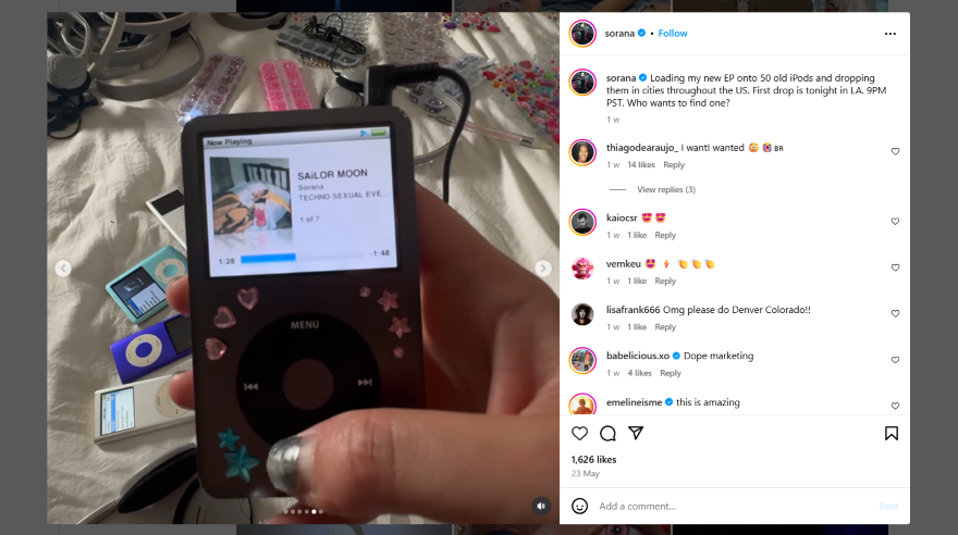 An Instagram photo post of a hand holding a decorated iPod displaying the song "Sailor Moon" on screen, surrounded by colorful accessories and other iPods.